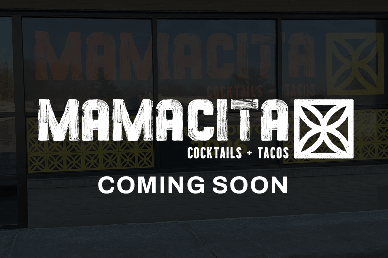 Mamacita Cocktails + Tacos Main logo in white overlaid a dark photograph of the front restaurant windows.
